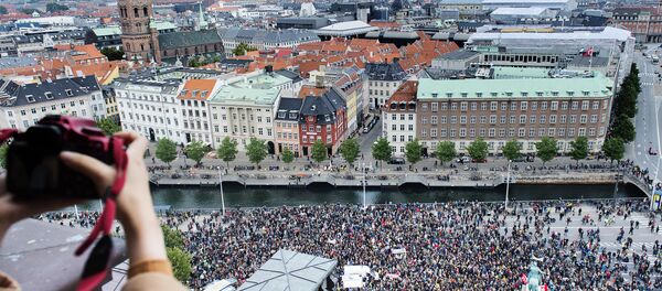A photographer takes a photo of some 30,000 people who joined a rally in Copenhagen on September 12, 2015 in favour of taking in thousands of refugees seeking shelter in Europe, police said - Sputnik International