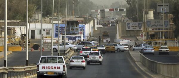 Iraqi security forces stand guard as vehicles move toward the gate of the heavily fortified Green Zone in Baghdad, Iraq, Monday, Oct. 5, 2015 - Sputnik International