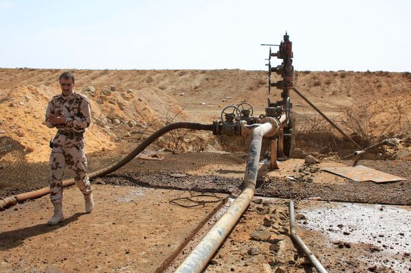 A member of the Syrian government forces walks next to a well at Jazel oil field, near the ancient city of Palmyra in the east of Homs province after they retook the area from Islamic State (IS) group fighters on March 9, 2015. A member of the Syrian government forces walks next to a well at Jazel oil field, near the ancient city of Palmyra in the east of Homs province after they retook the area from Islamic State (IS) group fighters on March 9, 2015. - Sputnik International