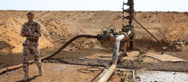 A member of the Syrian government forces walks next to a well at Jazel oil field, near the ancient city of Palmyra in the east of Homs province after they retook the area from Islamic State (IS) group fighters on March 9, 2015 - Sputnik International
