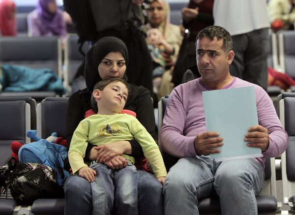 Syrian refugees wait to board a flight to Germany for temporary relocation, at Rafik Hariri International Airport in Beirut, Lebanon, Wednesday, Sept. 11, 2013. - Sputnik International