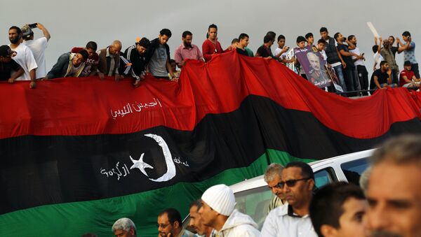 Libyans hold a large version of their national flag during a demonstration against a UN-brokered peace deal in the centre of the eastern coastal Libyan city of Benghazi on October 23, 2015 - Sputnik International