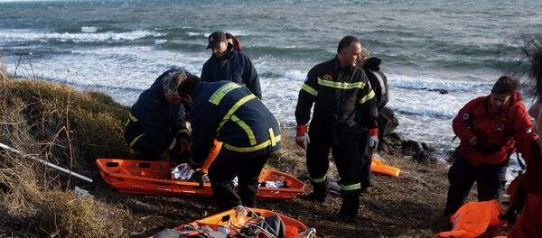 The bodies of refugees and migrants are covered with blankets after other migrants arrive by boats on the Greek island of Lesbos after crossing the Aegean sea from Turkey on October 25, 2015 - Sputnik International