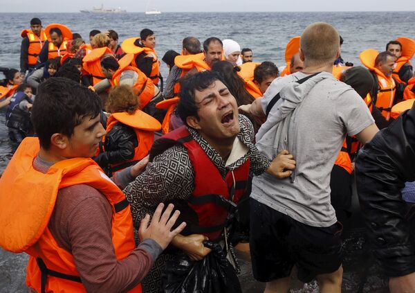 A Syrian refugee cries while disembarking from a flooded raft at a beach on the Greek island of Lesbos, after crossing a part of the Aegean Sea from the Turkish coast on an overcrowded raft, October 20, 2015 - Sputnik International