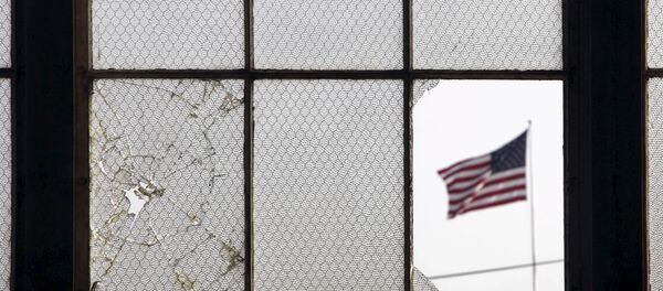 In this 2009 file photo, reviewed by the U.S. military, an American flag fluttering in the wind is pictured through a broken window from inside an airplane hangar used for media activities at Camp Justice, the site of the U.S. war crimes tribunal compound, at Guantanamo Bay U.S. Naval Base, Cuba, July 16, 2009 In this 2009 file photo, reviewed by the U.S. military, an American flag fluttering in the wind is pictured through a broken window from inside an airplane hangar used for media activities at Camp Justice, the site of the U.S. war crimes tribunal compound, at Guantanamo Bay U.S. Naval Base, Cuba, July 16, 2009 - Sputnik International