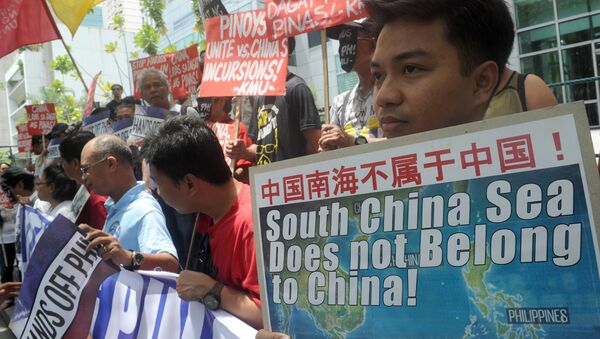 Protesters brandish placards at a rally in front of the Chinese Consulate in Manila's financial district on July 7, 2015, denouncing China's claim to most of the South China Sea including areas claimed by the Philippines - Sputnik International