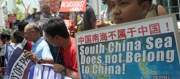 Protesters brandish placards at a rally in front of the Chinese Consulate in Manila's financial district on July 7, 2015, denouncing China's claim to most of the South China Sea including areas claimed by the Philippines Protesters brandish placards at a rally in front of the Chinese Consulate in Manila's financial district on July 7, 2015, denouncing China's claim to most of the South China Sea including areas claimed by the Philippines - Sputnik International