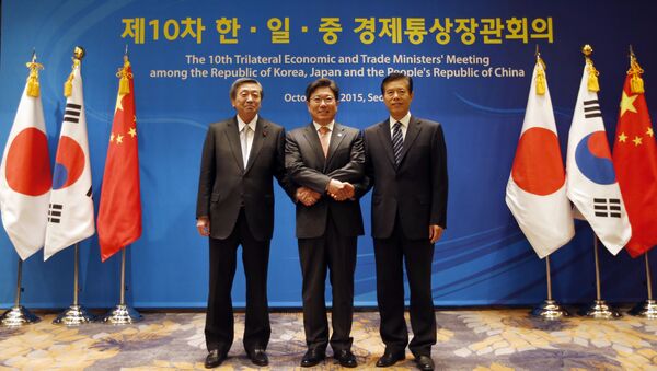 South Korea's Trade, Industry and Energy Minister Yoon Sang-jick, center, poses for the media with Japan's Economy, Trade and Industry Minister Motoo Hayashi, left, and China International Trade Representative Zhong Shan before the 10th trilateral economic and trade ministers' meeting in Seoul, South Korea, Friday, Oct. 30, 2015 - Sputnik International