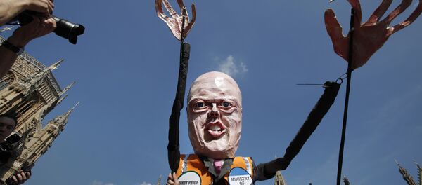 A protester carrying a puppet depicting Chris Grayling in central London, Tuesday, April 1, 2014. A protester carrying a puppet depicting Chris Grayling in central London, Tuesday, April 1, 2014. - Sputnik International