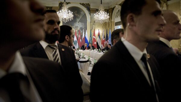 Security staff stand as US Secretary of State John Kerry (back L) and Russian Foreign Minister Sergei Lavrov (back 2nd L) chat before a meeting with 17 nations, the European Union and United Nations at the Hotel Imperial in Vienna, October 30, 2015 - Sputnik International