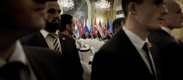 Security staff stand as US Secretary of State John Kerry (back L) and Russian Foreign Minister Sergei Lavrov (back 2nd L) chat before a meeting with 17 nations, the European Union and United Nations at the Hotel Imperial in Vienna, October 30, 2015 - Sputnik International