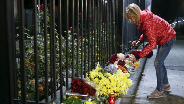 A woman places a candle for victims of a Russian airliner which crashed in Egypt, outside the Russian embassy in Kiev, Ukraine October 31, 2015 - Sputnik International