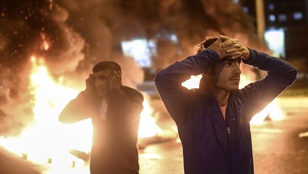 People react as smoke billows from burning pallets set on fire during clashes between Turkish riot policemen and Kurdish protesters in the southeastern city of Diyarbakir on November 1, 2015 - Sputnik International