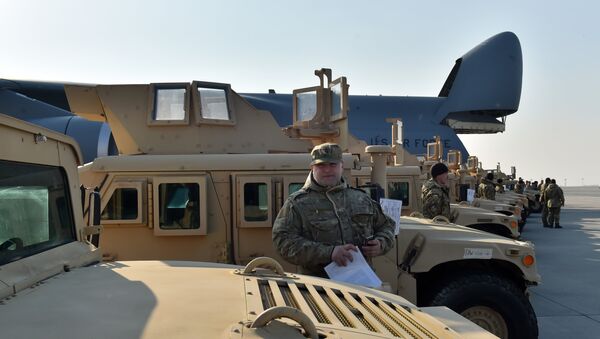 A Ukrainian serviceman holds a certificate at he stands next to an armoured car at Kiev airport on March 25, 2015 during a welcoming ceremony of the first US plane delivery of non-lethal aid, including 10 Humvee vehicles - Sputnik International