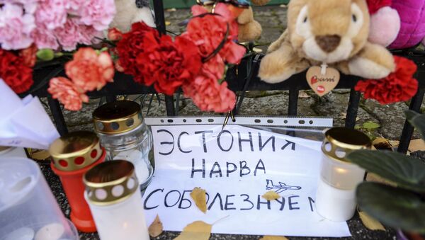 Flowers, candles, toys and a note that reads Estonia Narva Condolences in memory of the Airbus A321 crash victims, near the Russian consulate in Narva - Sputnik International