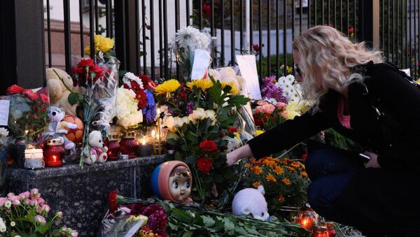 A woman lays flowers at the Russian Embassy in Kiev to mourn the victims of Kogalymavia's Airbus A321 passenger airliner - Sputnik International