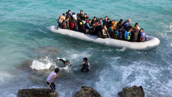 Refugees and migrants board a dingy as they set out, trying to travel from the Turkish coast to the Greek island of Chios, near Cesme, Turkey, Saturday, Oct. 31, 2015. - Sputnik International