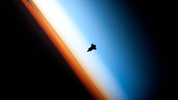 In a very unique setting over Earth's colorful horizon, the silhouette of the space shuttle Endeavour is featured in this photo by an Expedition 22 crew member on board the International Space Station, as the shuttle approached for its docking on Feb. 9 during the STS-130 mission. - Sputnik International