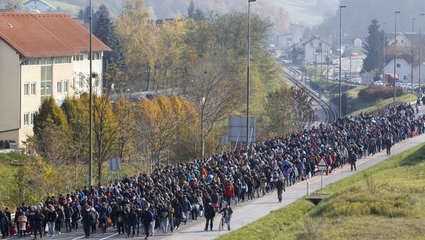 Migrants and refugee are escorted by Slovenian police officers toward the Slovenian-Austrian border crossing in Sentilj, Slovenia, Saturday, Oct. 31, 2015. - Sputnik International