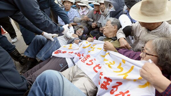 Protesters lie on the ground as they try to block work on a contentious U.S. air base in front of the gate of the U.S. Marine Corps Camp Schwab in Nago on the southern Japanese island of Okinawa - Sputnik International