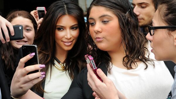 In this Friday, Sept. 21, 2012 file photo Kim Kardashian, left, is surrounded by her fans who are attempting to have their photographs taken with her as she leaves a radio station in Melbourne, Australia. - Sputnik International