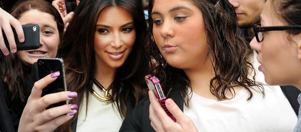 In this Friday, Sept. 21, 2012 file photo Kim Kardashian, left, is surrounded by her fans who are attempting to have their photographs taken with her as she leaves a radio station in Melbourne, Australia. In this Friday, Sept. 21, 2012 file photo Kim Kardashian, left, is surrounded by her fans who are attempting to have their photographs taken with her as she leaves a radio station in Melbourne, Australia. - Sputnik International