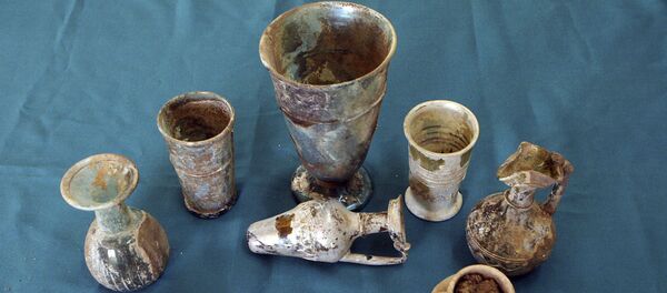 Glassware, potteries and golden earrings that have been recently unearthed by Syrian archeologists in a cemetery in Hina town. (File) Glassware, potteries and golden earrings that have been recently unearthed by Syrian archeologists in a cemetery in Hina town. (File) - Sputnik International
