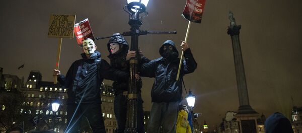 Anti-capitalist protesters wearing Guy Fawkes masks hold placards as they gather at Trafalgar Square ahead of the Million Masks March, organised by the group Anonymous, in London on November 5, 2015. Anti-capitalist protesters wearing Guy Fawkes masks hold placards as they gather at Trafalgar Square ahead of the Million Masks March, organised by the group Anonymous, in London on November 5, 2015. - Sputnik International