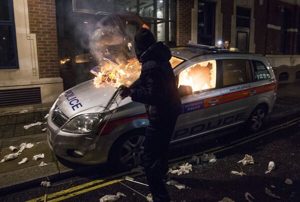 Anti-capitalist protesters attack a British police car during the Million Masks March, organised by the group Anonymous, near the Houses of Parliament in London on November 5, 2015. - Sputnik International