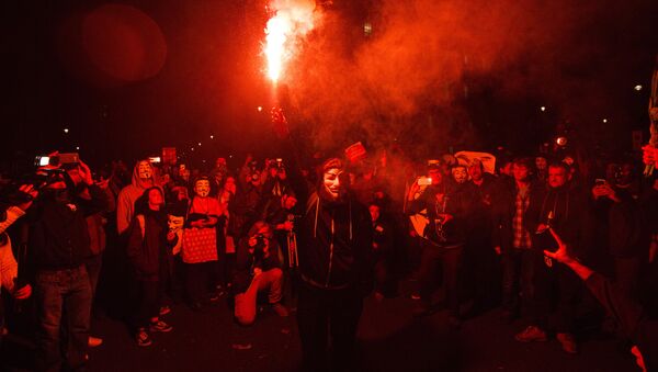 An anti-capitalist protester wearing a Guy Fawkes mask holds a lit flare during the Million Masks March, organised by the group Anonymous, near the Houses of Parliament in central London on 5 November 2015. - Sputnik International