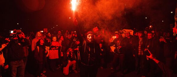An anti-capitalist protester wearing aGuy Fawkes mask holds a lit flare during the Million Masks March, organised by the group Anonymous, near the Houses of Parliament in central London on November 5, 2015. An anti-capitalist protester wearing aGuy Fawkes mask holds a lit flare during the Million Masks March, organised by the group Anonymous, near the Houses of Parliament in central London on November 5, 2015. - Sputnik International