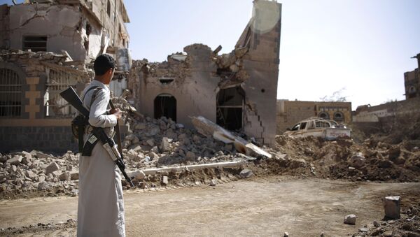 A Shiite fighter, known as a Houthi, look at a house destroyed by Saudi-led airstrikes in Sanaa, Yemen (File) - Sputnik International