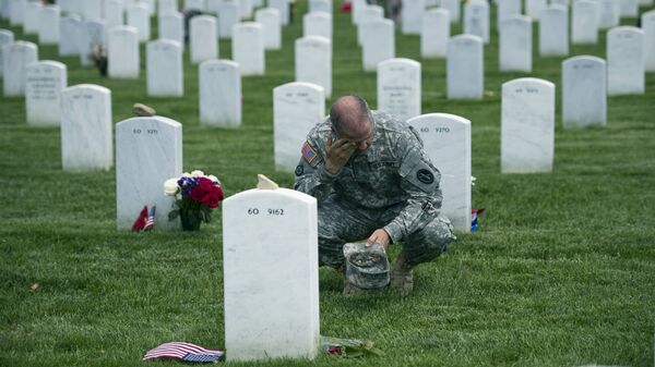 Army Col. Matthew Rasmussen of the Army Military District of Washington, wipes tears from his eyes while visiting the grave of Army Staff Sgt. Richard Tieman, 28, of Waynesboro, Pa., places flags at grave sites at Arlington National Cemetery in Arlington, Va., Thursday, May 22, 2014 - Sputnik International