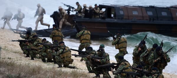 Portuguese Fuzileiros secure an area after disembarking from an amphibious transport during an exercise as part of the NATO's Trident Juncture 2015 in Troia, 100 kms south of Lisbon on November 5, 2015 - Sputnik International