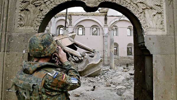A German KFOR soldier takes photographs of the destroyed St. George Orthodox church in Prizren 22 March 2004 - Sputnik International