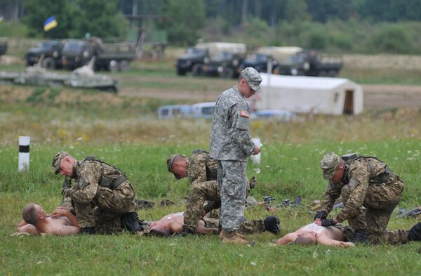 US serviceman teaches Ukrainian soldiers how to give emergency medical aid during the Rapid Trident/Saber Guardian 2015 military exercises at the International Peacekeeping and Security Centre base outside Lviv, Ukraine, Friday, July 24, 2015 US serviceman teaches Ukrainian soldiers how to give emergency medical aid during the Rapid Trident/Saber Guardian 2015 military exercises at the International Peacekeeping and Security Centre base outside Lviv, Ukraine, Friday, July 24, 2015 - Sputnik International