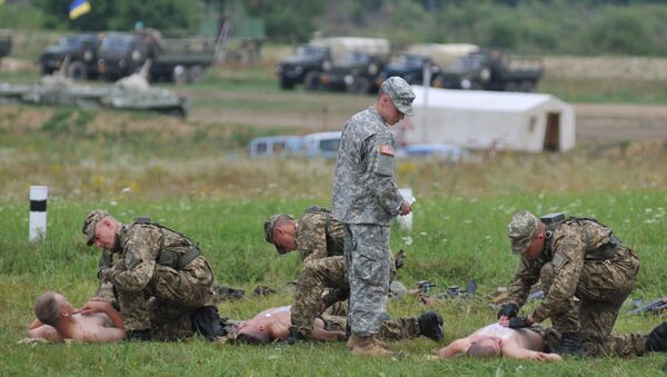 US serviceman teaches Ukrainian soldiers how to give emergency medical aid during the Rapid Trident/Saber Guardian 2015 military exercises at the International Peacekeeping and Security Centre base outside Lviv, Ukraine, Friday, July 24, 2015 - Sputnik International