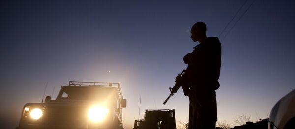 An Israeli soldier blocks a road in the village of Halhul, near the West Bank town of Hebron. An Israeli soldier blocks a road in the village of Halhul, near the West Bank town of Hebron. - Sputnik International