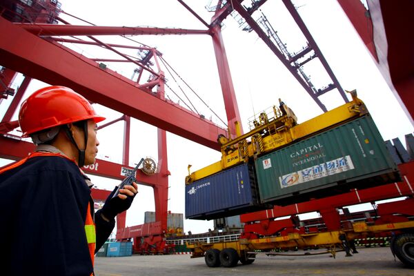 This photo taken on January 8, 2012 shows a worker operating hoists to unload containers at the Kaikou port, in south China's Hainan province This photo taken on January 8, 2012 shows a worker operating hoists to unload containers at the Kaikou port, in south China's Hainan province - Sputnik International
