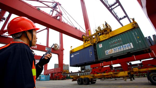 This photo taken on January 8, 2012 shows a worker operating hoists to unload containers at the Kaikou port, in south China's Hainan province - Sputnik International