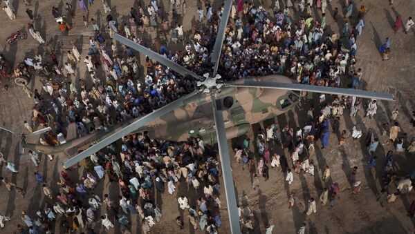 Pakistanis crowd around a Pakistan Army helicopter during a drop of much needed food supplies to the flood encircled village of Tul in , Sindh Province, southern Pakistan, Friday, Aug. 20, 2010 - Sputnik International