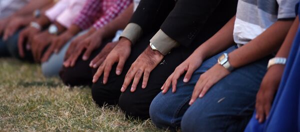 Muslim men kneel to pray in front of MacArthur High School at a prayer vigil in support of Ahmed Mohamed, Thursday, Sept. 17, 2015, in Irving, Texas - Sputnik International