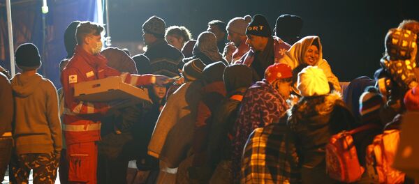 Migrants wait on the bridge at the Austrian-German border between Braunau and Simbach at lake Inn near Passau, Germany, October 27, 2015 Migrants wait on the bridge at the Austrian-German border between Braunau and Simbach at lake Inn near Passau, Germany, October 27, 2015 - Sputnik International