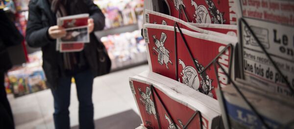 A man holds the latest edition of French satirical weekly newspaper Charlie Hebdo at a train station in Paris. File photo A man holds the latest edition of French satirical weekly newspaper Charlie Hebdo at a train station in Paris. File photo - Sputnik International
