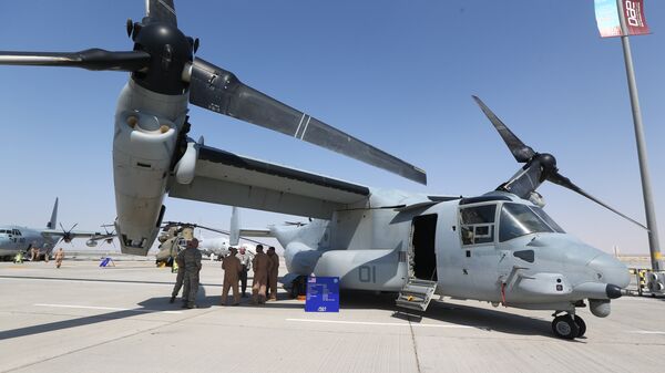 US soldiers stand in the shade of the wing of a Bell Boeing V-22 Osprey, a US multi-mission, tiltrotor military aircraft, displayed at the Dubai Airshow on November 8, 2015 - Sputnik International