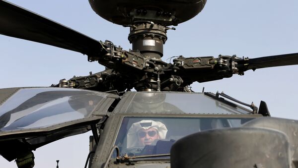 An Emirati man checks out an Apache helicopter during the opening of the Dubai Airshow in United Arab Emirates, Sunday, Nov. 8, 2015 - Sputnik International
