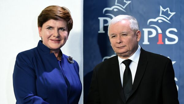 Jaroslaw Kaczynski (R), the leader of the conservative Law and Justice (PiS) party, shakes hands with designated prime minister Beata Szydlo after she announced members of her new cabinet on November 9, 2015 in Warsaw - Sputnik International