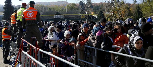 Austrian army soldiers observe migrants as they wait to cross the border from the village of Sentilj, Slovenia into Spielfeld in Austria, November 2, 2015 Austrian army soldiers observe migrants as they wait to cross the border from the village of Sentilj, Slovenia into Spielfeld in Austria, November 2, 2015 - Sputnik International