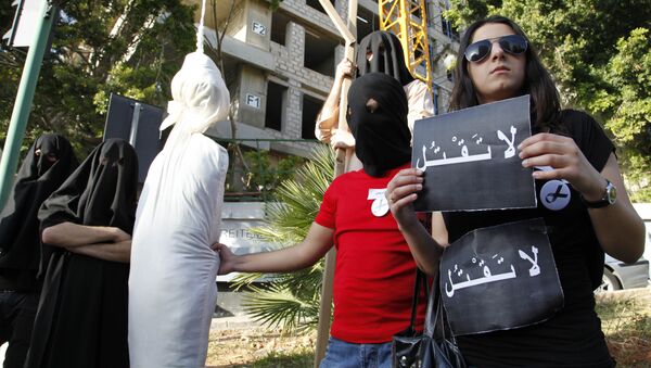 Activists from a civil organization reenact an execution scene in front of the Saudi Arabia Embassy in Beirut, Lebanon, Thursday, April 1, 2010, as they protest a possible beheading of a Lebanese man accused of witchcraft in Saudi Arabia. The lawyer of Lebanese TV psychic Ali Sibat who was convicted in Saudi Arabia for witchcraft said Thursday her client could be beheaded this week and urged Lebanese and Saudi leaders to help spare his life. The Arabic writing on banners read:don't kill. - Sputnik International
