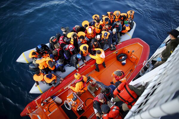 Refugees and migrants board the Turkish Coast Guard Search and Rescue ship Umut-703, off the shores of Canakkale, Turkey, after a failed attempt at crossing to the Greek island of Lesbos, November 9, 2015 Refugees and migrants board the Turkish Coast Guard Search and Rescue ship Umut-703, off the shores of Canakkale, Turkey, after a failed attempt at crossing to the Greek island of Lesbos, November 9, 2015 - Sputnik International